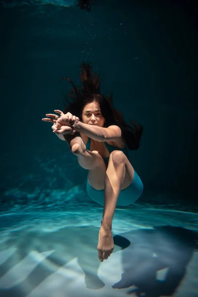 Dívka se věnuje józe pod vodou ve sportovním oblečení. Ásany a meditace — Stock fotografie