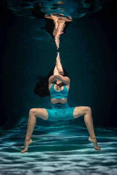 Het meisje is bezig met yoga onder water in sportkleding. Asana 's en meditatie — Stockfoto