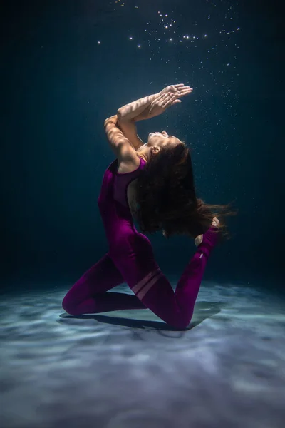Het meisje is bezig met yoga onder water in sportkleding. Asana 's en meditatie — Stockfoto