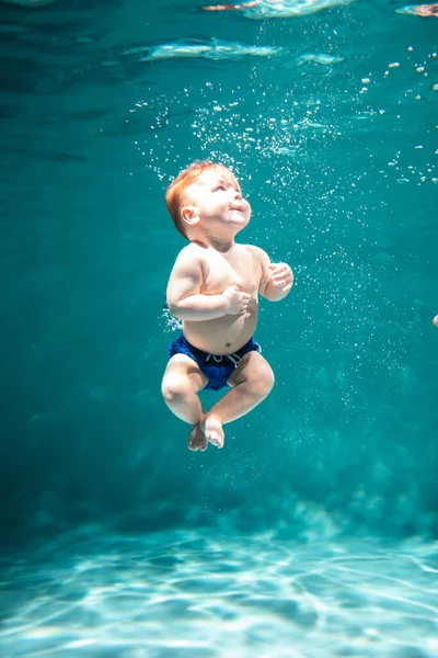 Słodkie Kid Dives w basenie. Przestrzeń kopiowania — Zdjęcie stockowe