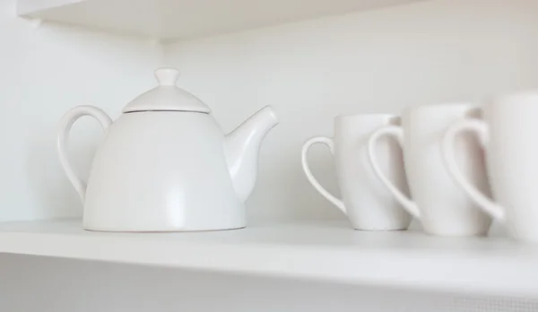 Teapot and cups on the shelf — Stock Photo, Image