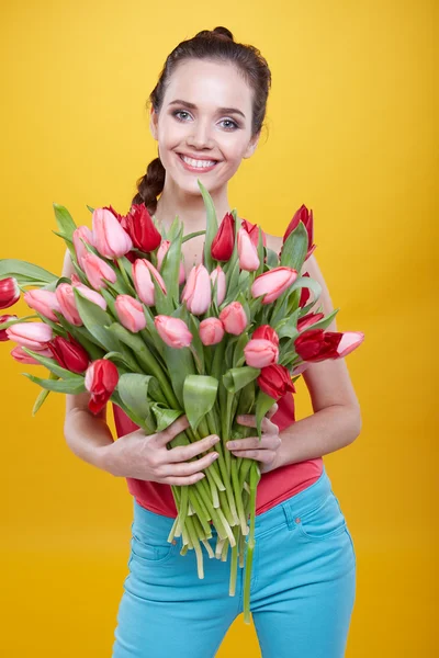 Femme avec des fleurs de tulipes — Photo