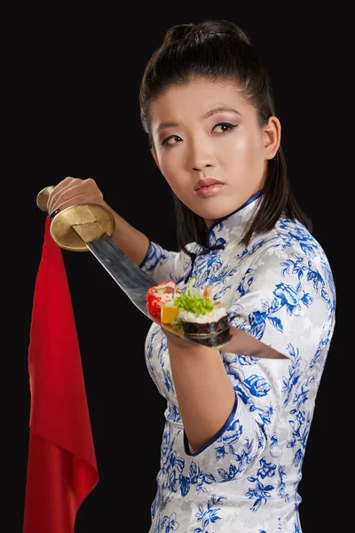 Kobieta gospodarstwa sushi na katana — Zdjęcie stockowe