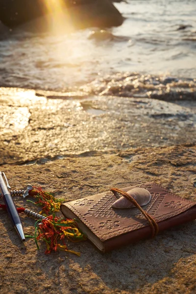 Rocky beach with old notebook — Stock Photo, Image