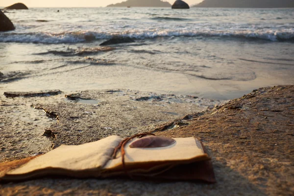 Rocky beach with old notebook — Stock Photo, Image