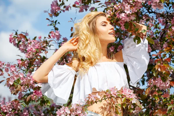 Woman in flowering spring garden — Stock Photo, Image