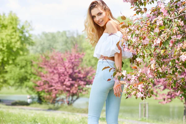 Vrouw in bloeiende lentetuin — Stockfoto