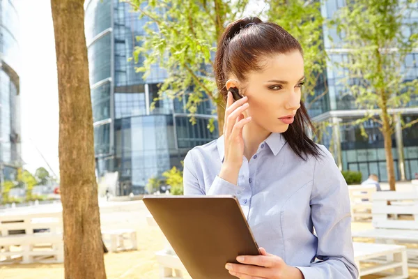 Affärskvinna arbetar med Bluetooth-headset — Stockfoto