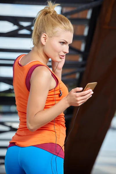 Atleta feminina com telefone celular — Fotografia de Stock