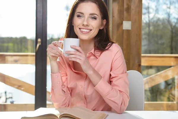 Frau sitzt am Holztisch — Stockfoto