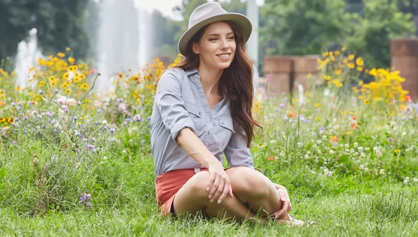 Lente vrouw zit op gras — Stockfoto