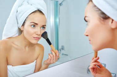 Makyaj fırça tutan genç kadın