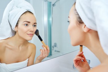 Makyaj fırça tutan genç kadın