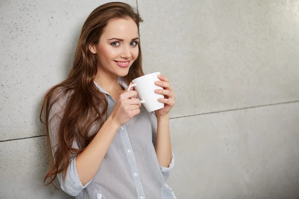 Woman on couch with cup — Stock Photo, Image