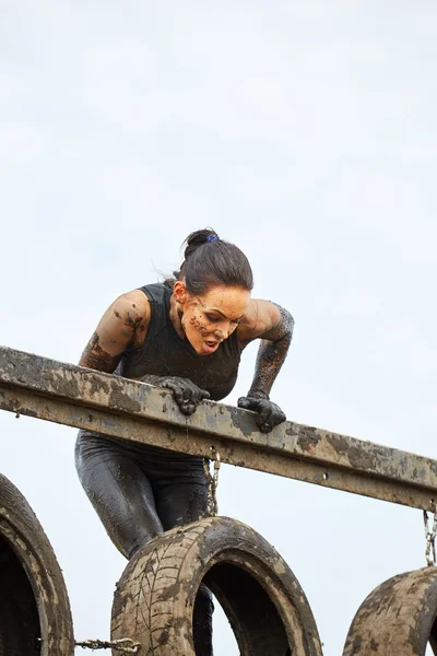 Woman climbs in top on barrier — Stock Photo, Image