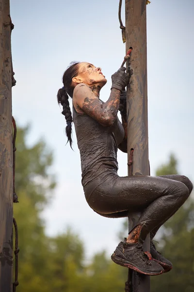 woman climbs in top on wooden barrier