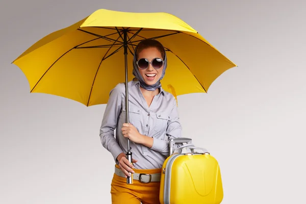 Frau mit Regenschirm und Koffer — Stockfoto