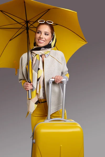 Frau mit Regenschirm und Koffer — Stockfoto