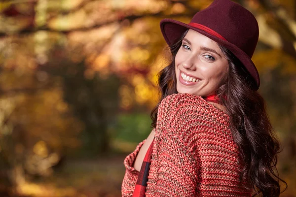 Frau im Hintergrund roter und gelber Blätter — Stockfoto