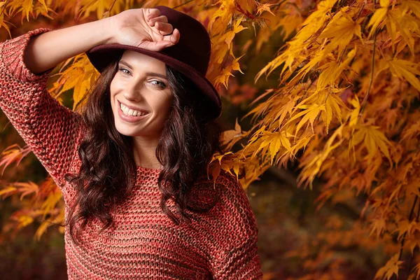 Frau im Hintergrund roter und gelber Blätter — Stockfoto