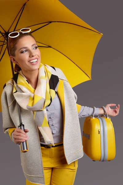 Woman with umbrella and suitcase — Stock Photo, Image