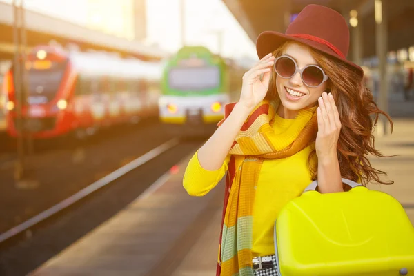 Mujer joven y bonita en una estación de tren — Foto de Stock