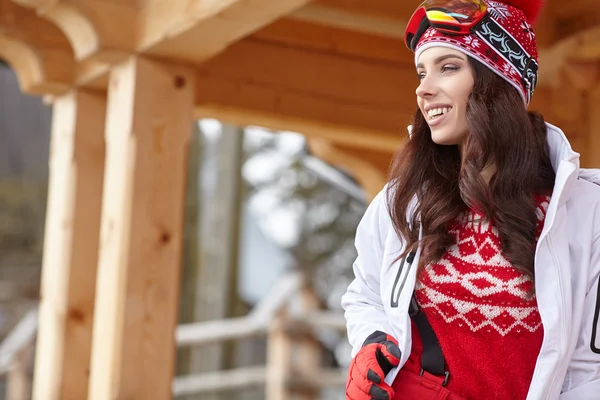 Vrouw skiër in houten huis terras — Stockfoto