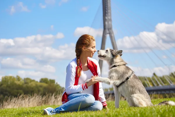 Belle fille jouer avec chien en plein air — Photo