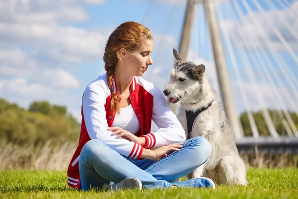 Belle fille jouer avec chien en plein air — Photo