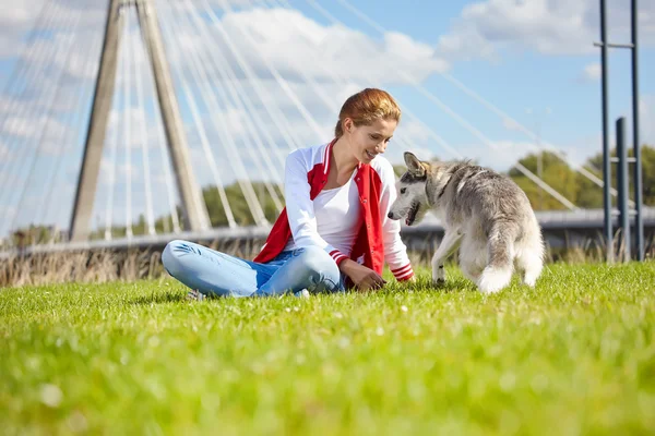 Mooi meisje met hond buiten spelen — Stockfoto