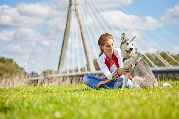 Belle fille jouer avec chien en plein air — Photo