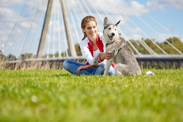 Beautiful girl playing with dog outdoors — Stock Photo, Image