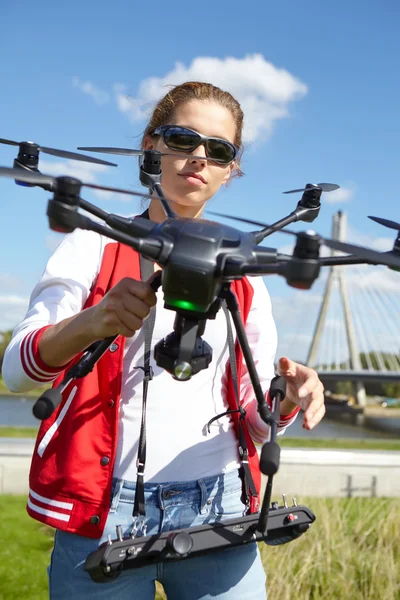 Mulher com controle remoto e drone de vigilância voadora — Fotografia de Stock