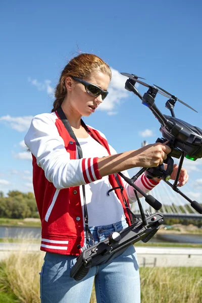 Mulher com controle remoto e drone de vigilância voadora — Fotografia de Stock