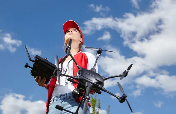 Mulher com controle remoto e drone de vigilância voadora — Fotografia de Stock