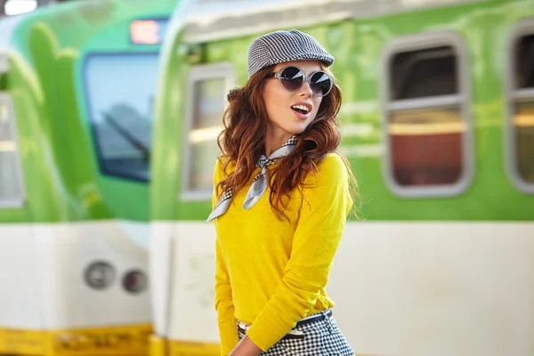 Mooie jonge vrouw op een treinstation — Stockfoto