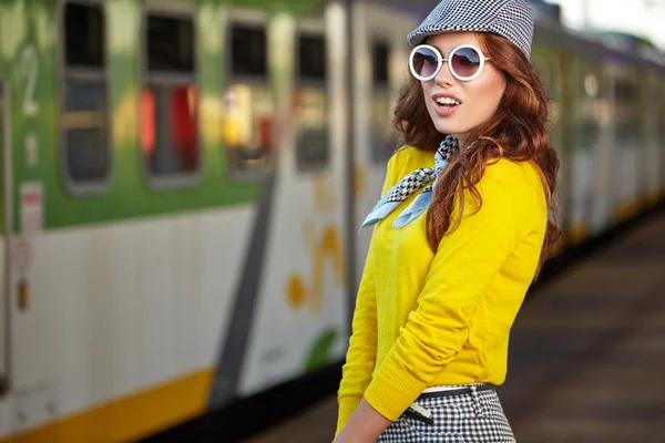 Mooie jonge vrouw op een treinstation — Stockfoto