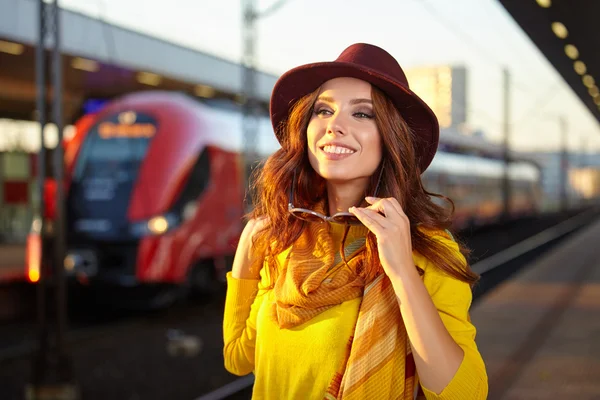 Bella giovane donna in una stazione ferroviaria — Foto Stock