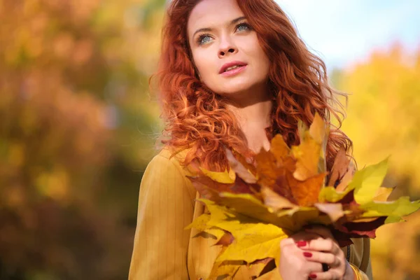 Doğada Sonbahar Yaprakları Tutan Kızıl Saçlı Hoş Bir Kadın — Stok fotoğraf