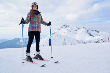         Kar dağında kar maskesi takmış beyaz şifalı kadın kayakçı.                          
