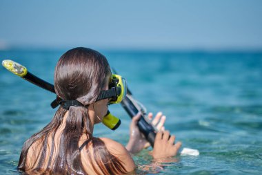 Bikinili bir kadın yaylı tüfekle avlanır.