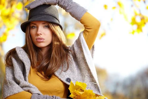 Vrouw met herfst bladeren in de hand — Stockfoto