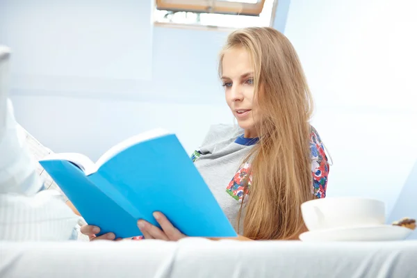 Женщина читает книгу в постели — стоковое фото