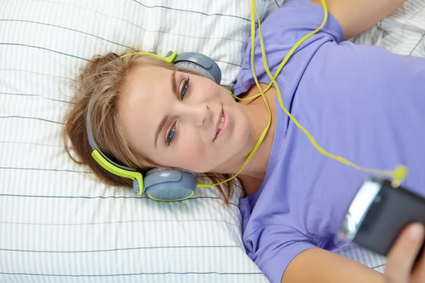 Közben zenét hallgatni ágyon nő — Stock Fotó
