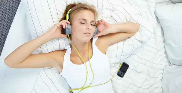 Femme couchée sur le lit tout en écoutant de la musique — Photo