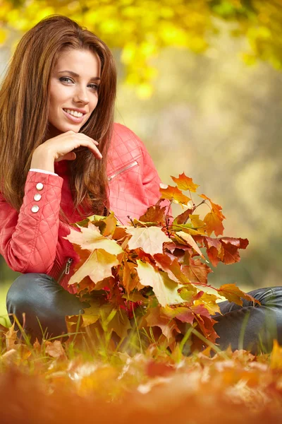 Vrouw met herfstbladeren — Stockfoto