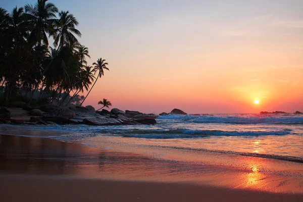 Západ slunce a tropickou pláž — Stock fotografie