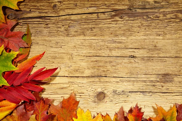 Autumn leaves on wooden table — Stock Photo, Image