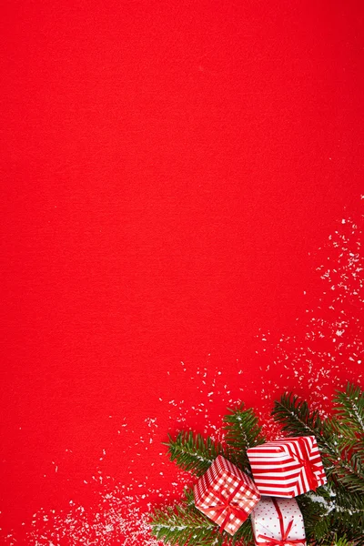 Κόκκινο φόντο με δώρα και χριστουγεννιάτικο δέντρο — Φωτογραφία Αρχείου