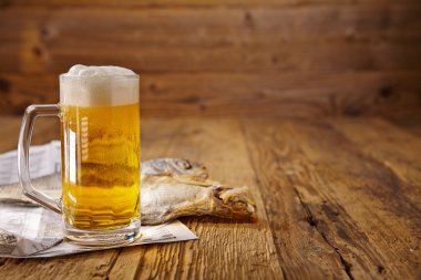Bira ve ahşap masa üzerinde kurutulmuş balık